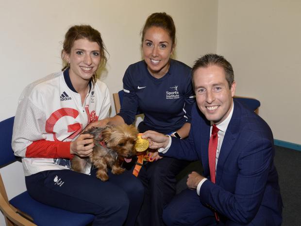 Sports Minister Paul Givan, MLA has welcoms swimmer Bethany Firth back to Northern Ireland after her historic performance in Rio. Bethany is pictured with her Yorkshire Terrier, Russell and Orla O'Rourke from Sports Institute.