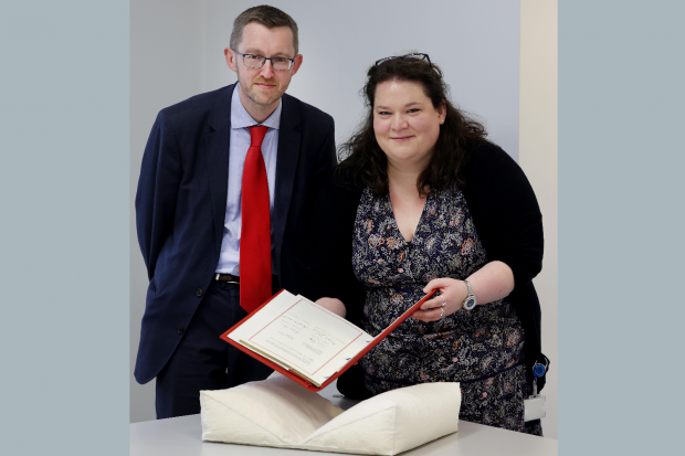 Two PRONI staff members with Good Friday Agreement document in front of them
